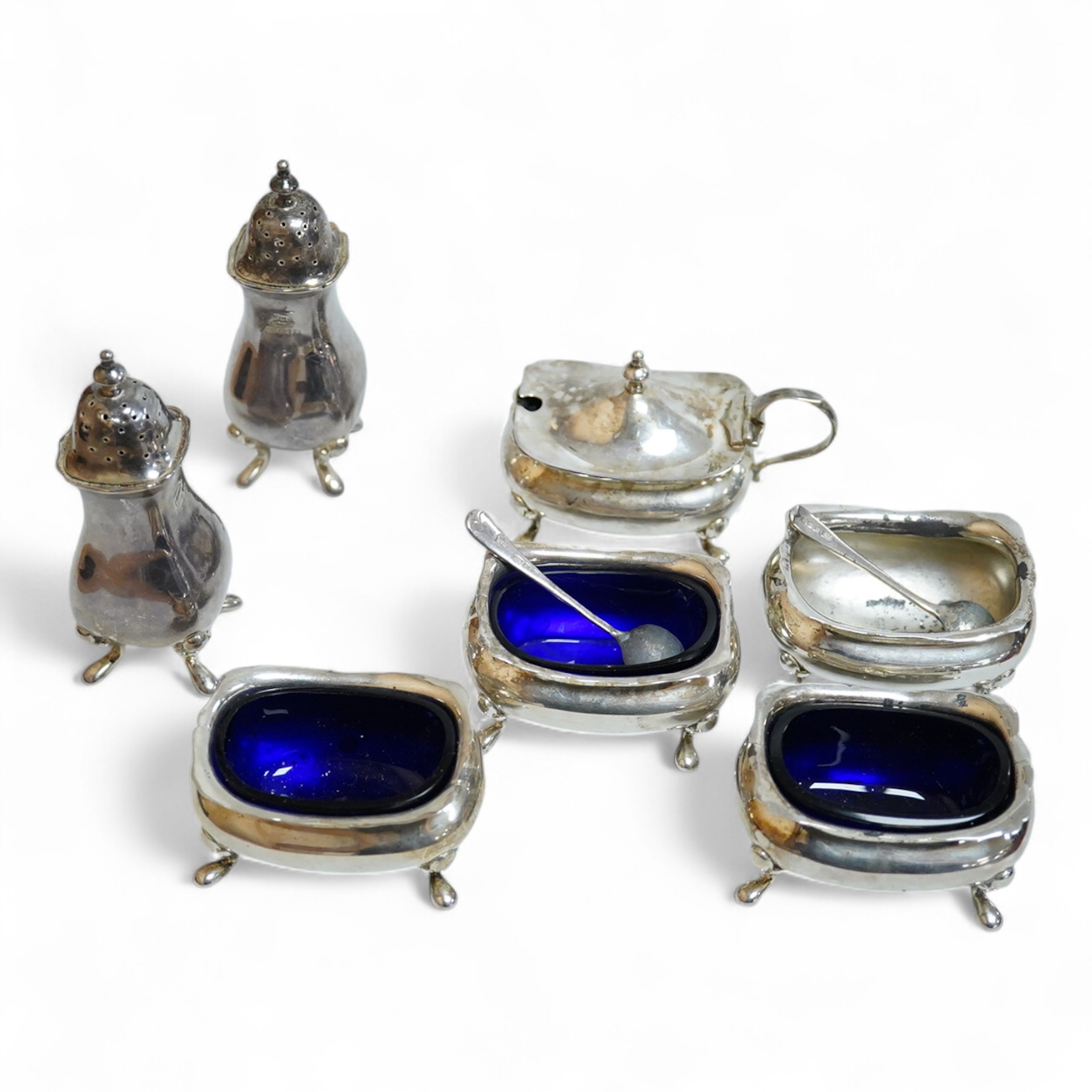 Four assorted silver salts, a silver mustard pot and two silver pepperettes, including Walker & Hall, Birmingham, 1900, some marks rubbed.